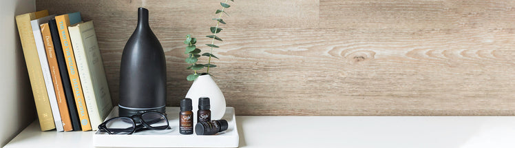 Aroma Om Diffuser placed with a stack of books and glasses