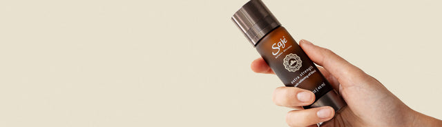 A person holding extra strength pain relieving oil blend