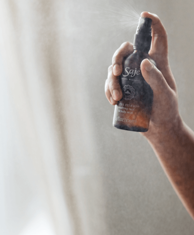 Person spraying Stress Release mist in front of a bright window