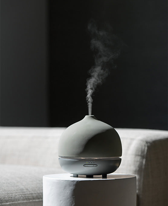 Aroma om deluxe diffuser styled on a wood table. 