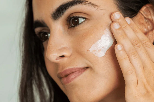 women applying facial moisturizer