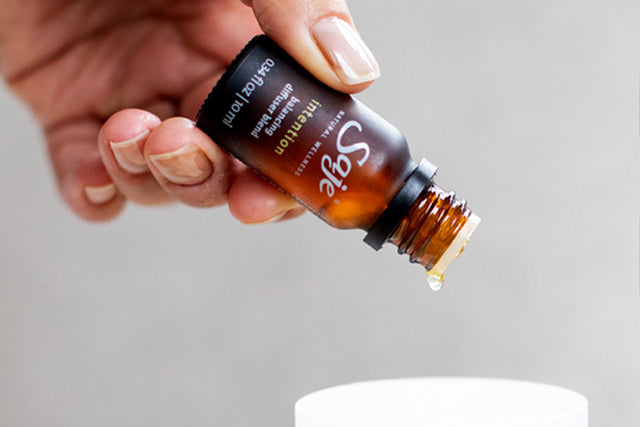 dropping essential oil from a diffuser blend in a diffuser