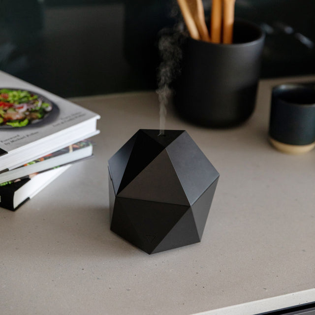 Black Aroma Be Free diffuser diffusing on grey counter