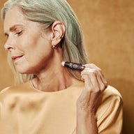 person rolling Connection roll-on by Saje on neck