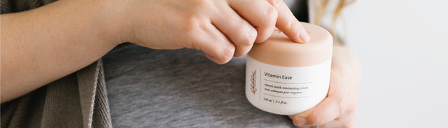 A person opening vitamin ease stretch mark minimizing cream 