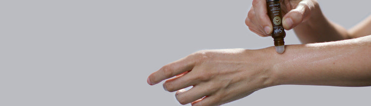 Saje Pain Release Roll-on being applied to a person's forearm