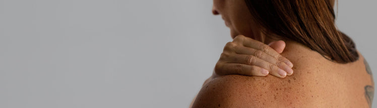 A person rubbing pain release into their shoulder