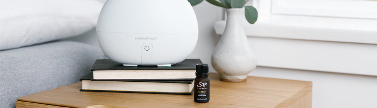 Saje Diffuser on a stack of books placed with diffuser blend