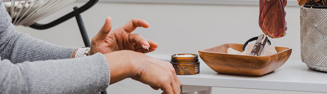 Close up of a person applying Saje Muscle Melt Body Butter to their hand