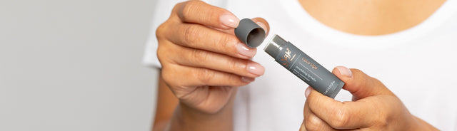 A person removing the cap of coco lips 