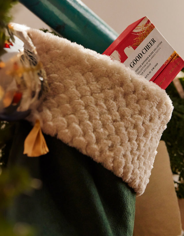 Saje packaging in a beige stocking, green wrapping paper in the background.