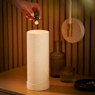 Person adding drops of a Saje diffuser blend into a Aroma Light Diamond diffuser