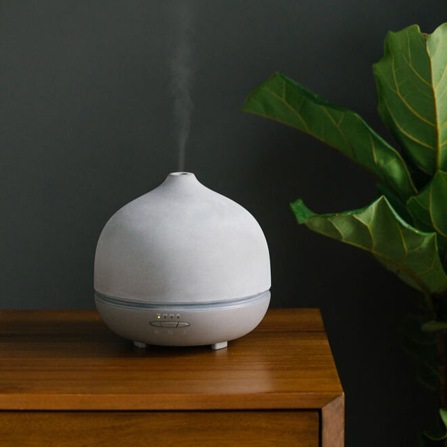 Stone grey aroma om deluxe diffuser on brown table