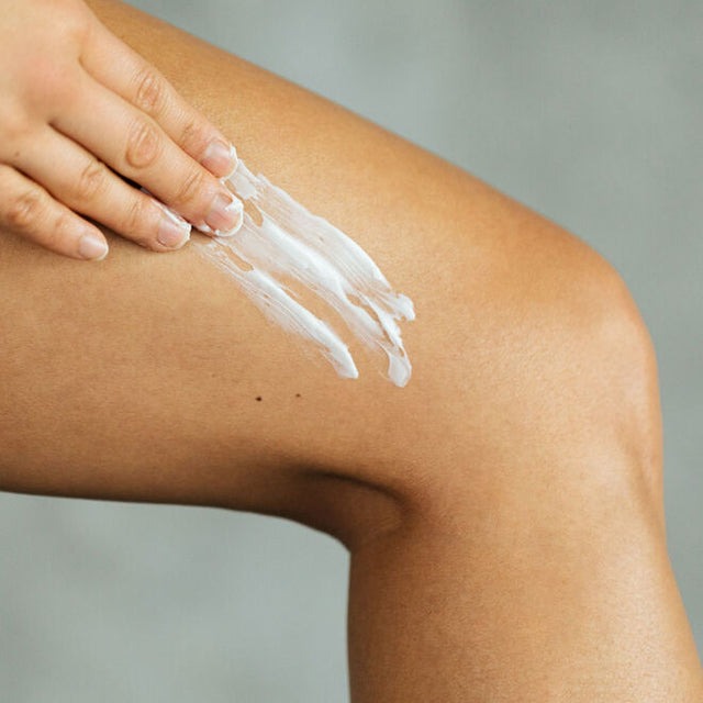 Hand applying body butter to leg