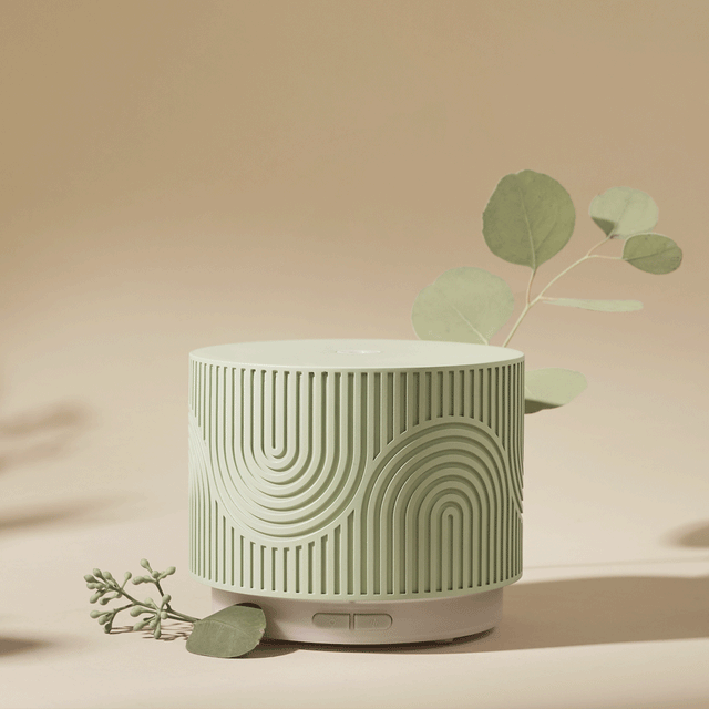 Pistachio green aroma nook diffuser with greenery on beige background
