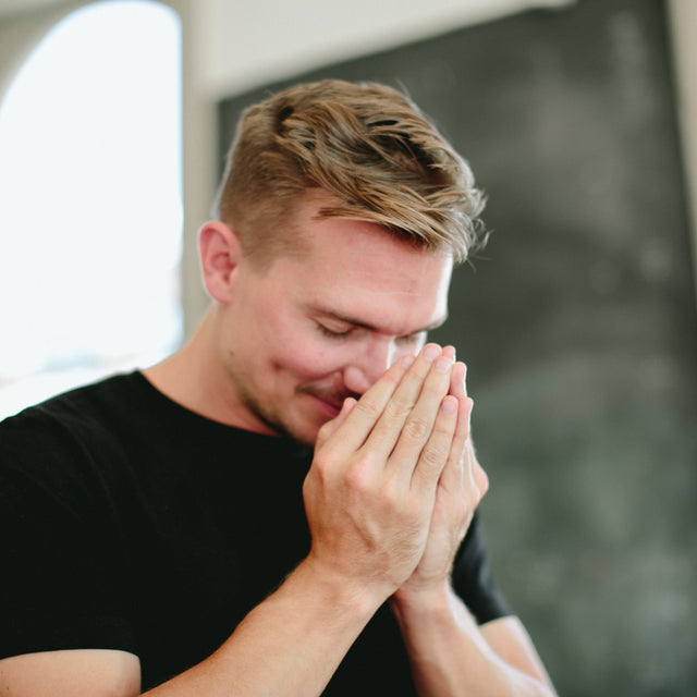 A man cupping his hands to his nose - in what is called a Saje breath