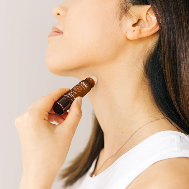 person applying Aroma Fairy 10ml roll-on to neck