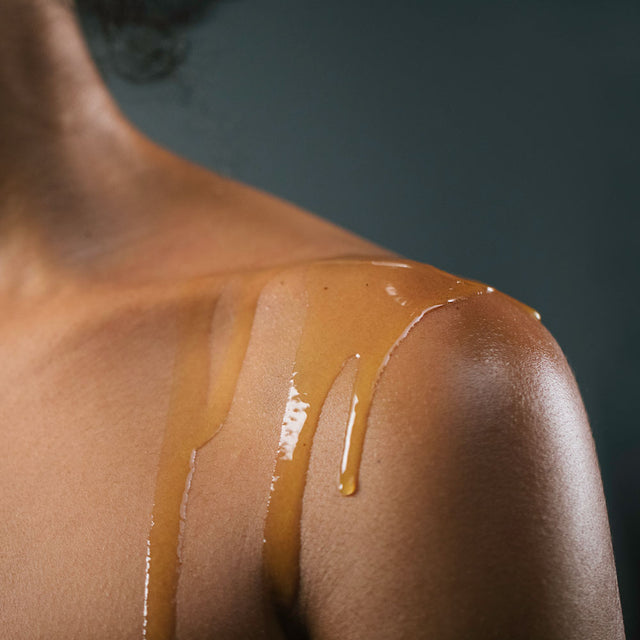 Pain release body oil dripping down a person shoulder 