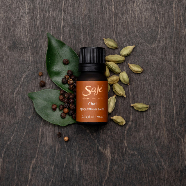 Chai spicy diffuser blend with its ingredients on a wooden background