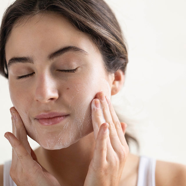 person lathering Claritea Soap Bar on face