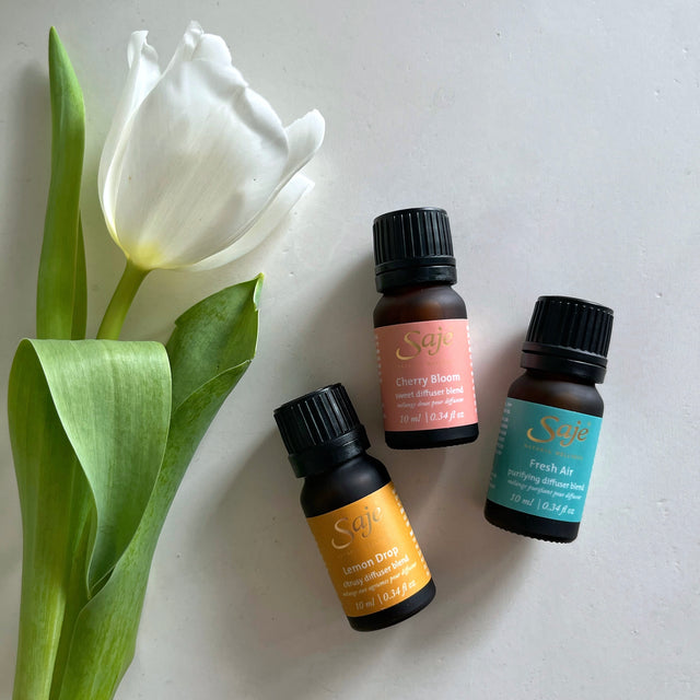 Saje Natural Wellness spring diffuser blends with a white tulip next to it