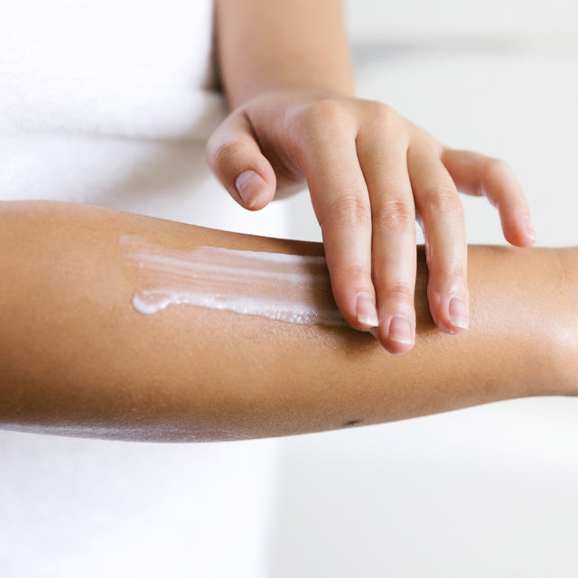 person using Saje Yoga Body Butter on arms