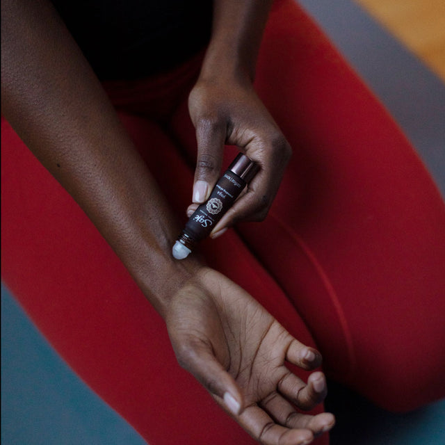 person applying Yoga roll-on